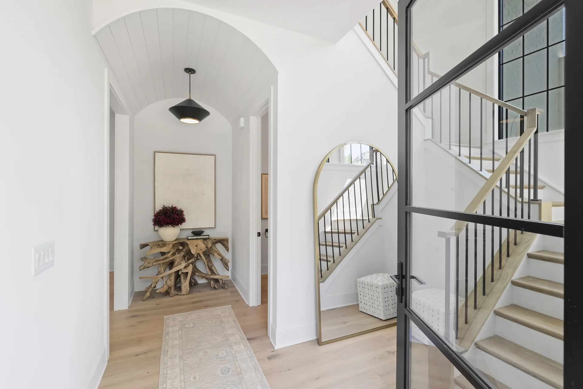 Arched openings, staircase, and connected sightlines in the completed 1205 Jersey Ln home.